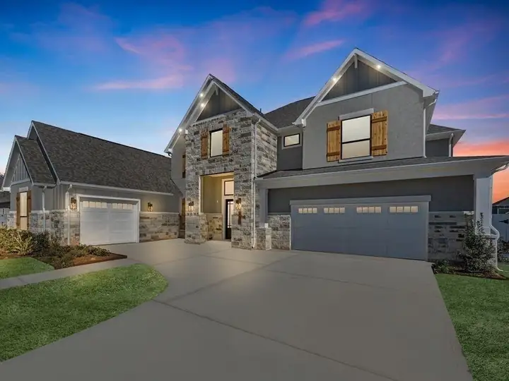 A newly built stone and stucco home with wood shutters